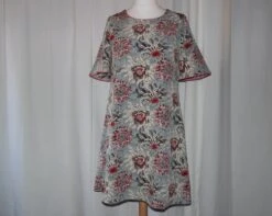 Robe Trapèze Ample à Manches Courtes Réalisée Dans Un Tissu à Fleurs Rouges Et Roses Sur Fond Beige Et Bleu